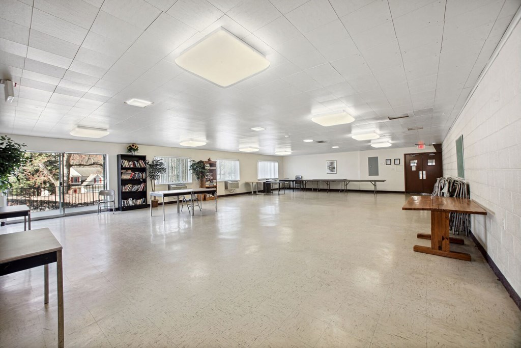 a large room with a white ceiling and tables and chairs