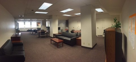 A large open office space with desks, chairs, and cubicles.