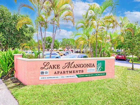 A sign for Lake Mangonia Apartments is displayed in front of some trees.