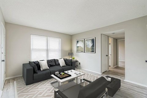 A living room with a grey couch and a coffee table.