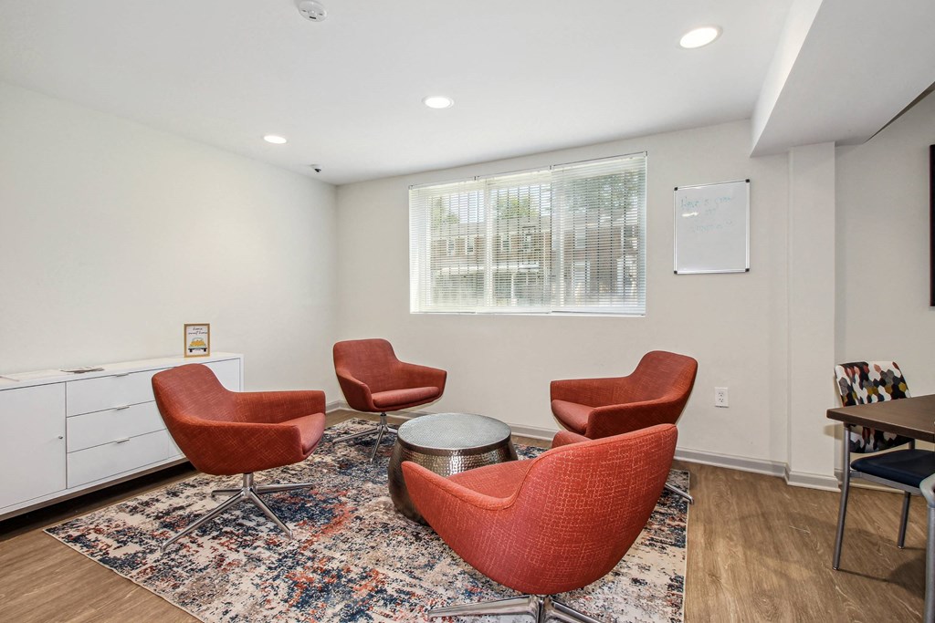 a living room with chairs and a table and a window
