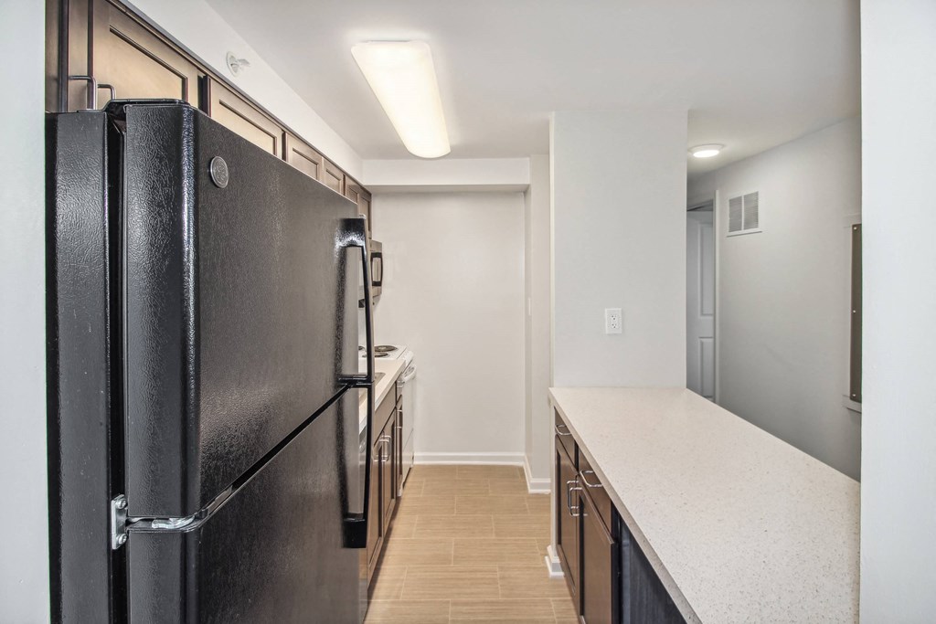 a kitchen with a black refrigerator and white counter tops