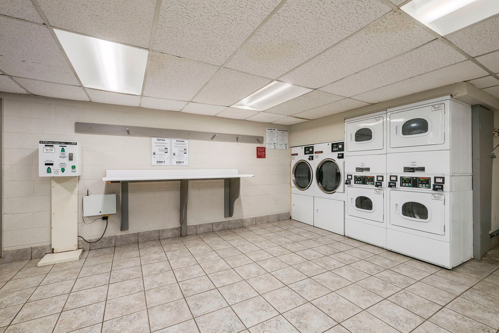 a laundry room with washers and dryers and a table