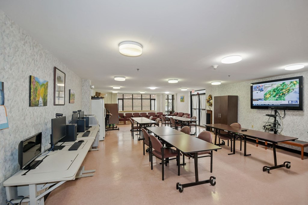 a conference room with tables and chairs and a tv