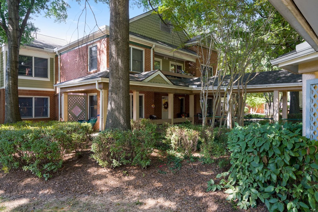 the front yard of a house with trees and bushes