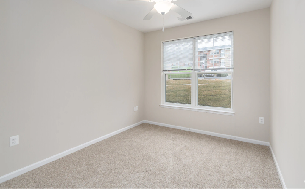 an empty room with a window and carpet