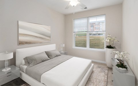 A bedroom with a large bed, a nightstand with a lamp, and a large painting on the wall.