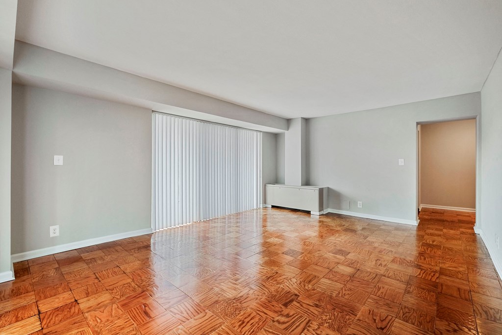 an empty living room with wood flooring and sliding glass doors