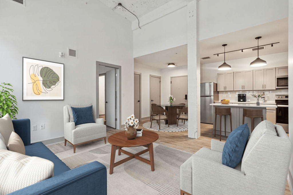 a living room and kitchen with couches and a table