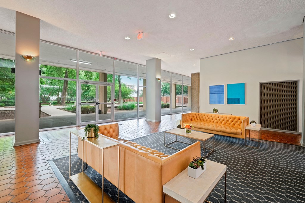 A modern waiting room with a sofa, coffee table, and a view of the outdoors.