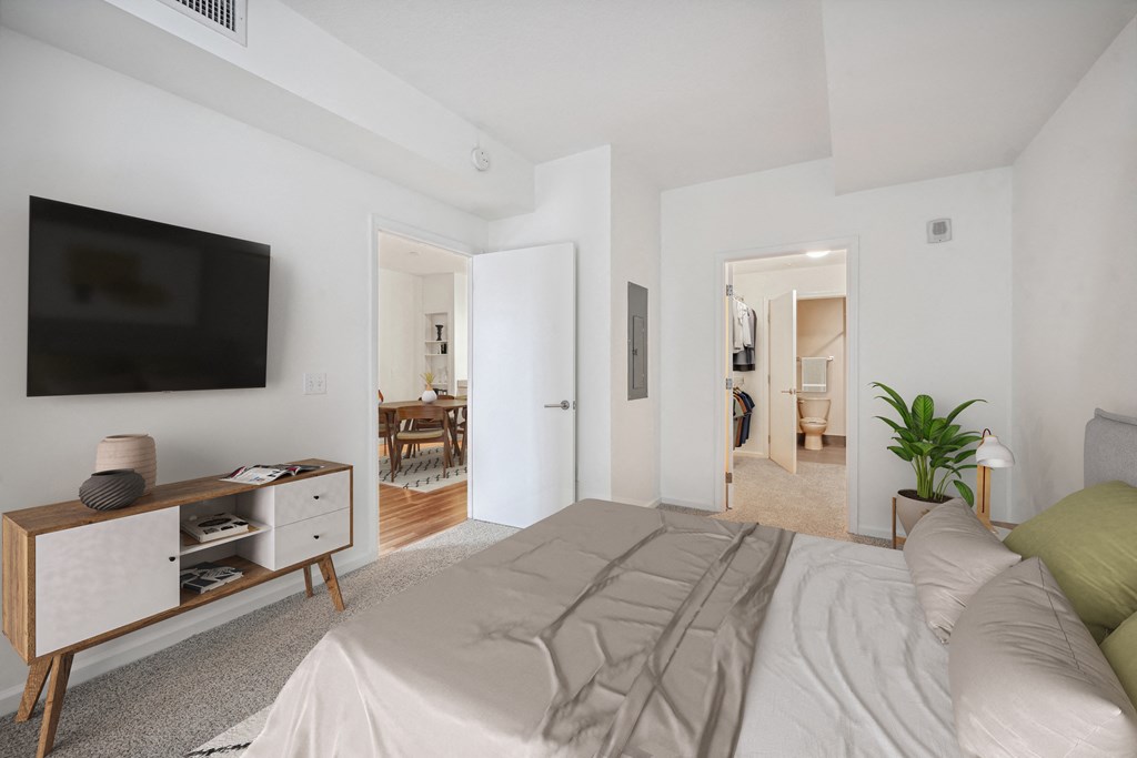 a bedroom with a large bed and a tv on the wall