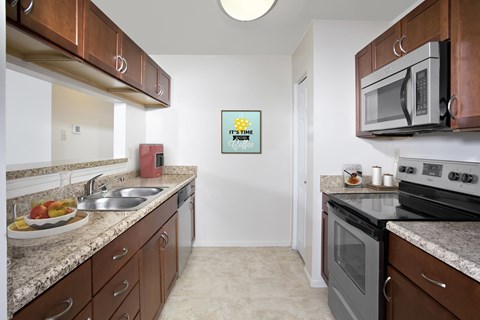 A kitchen with brown cabinets and a white fridge.