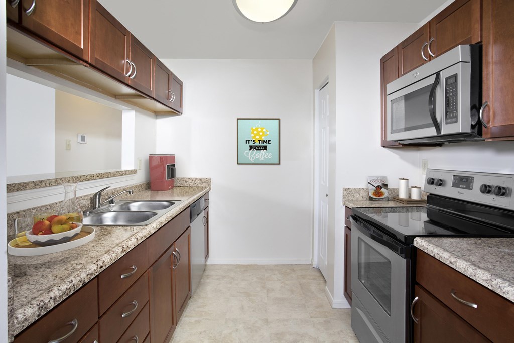 A kitchen with brown cabinets and a white fridge.