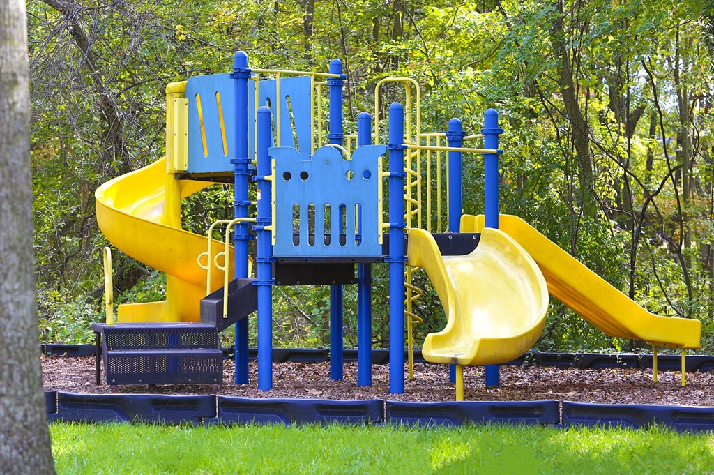 A playground with a blue and yellow slide.