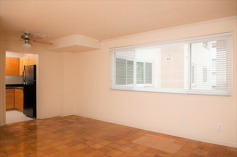 A room with a ceiling fan and a window with blinds.