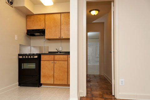 A kitchen with wooden cabinets and a black oven.
