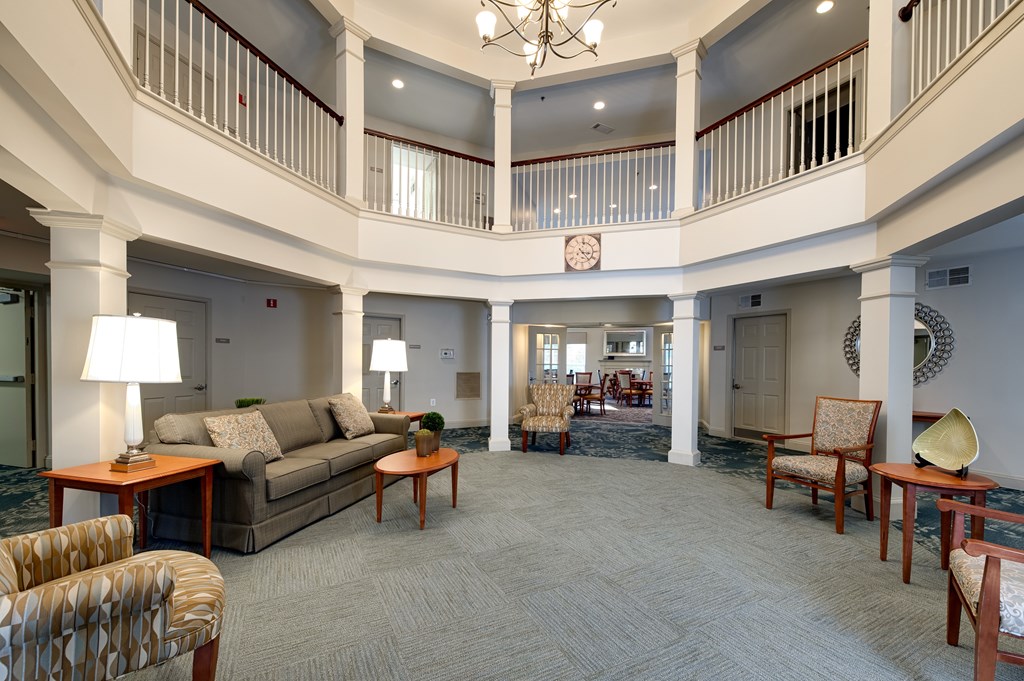 A large, open living room with a balcony and a chandelier.
