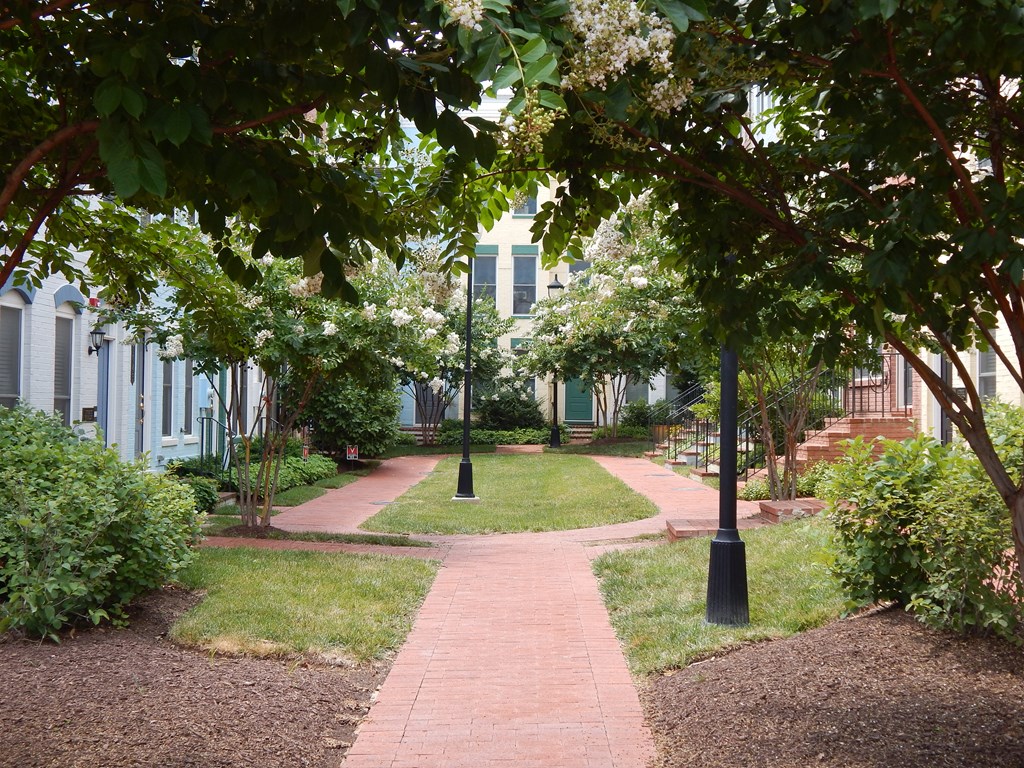 A pathway with a grassy area on either side and a building in the background.