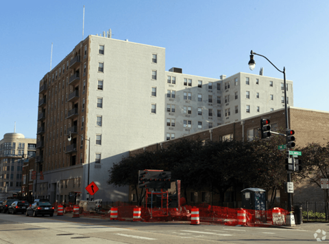 A street view of a building with a traffic light and a construction site in front of it.