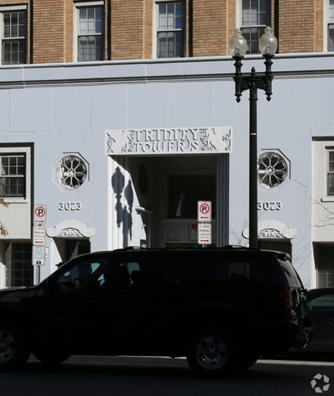 A black van is parked in front of a white building with a sign that reads "Stillwater Stouffer's.".