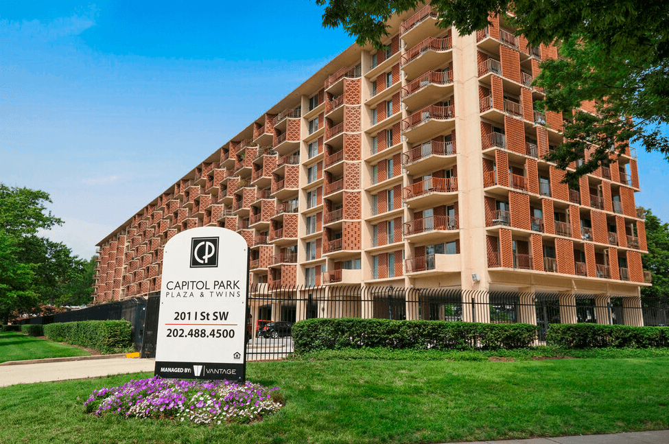 A brick building with a sign in front that says Capitol Park.