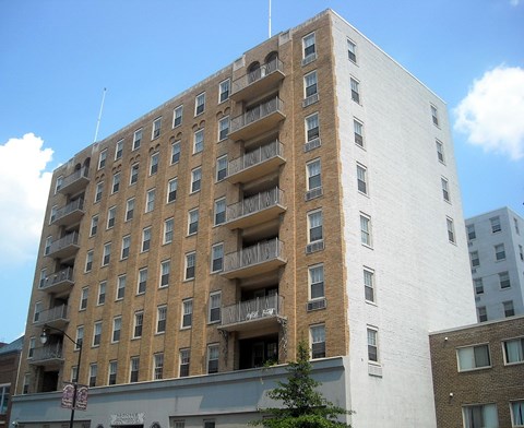 A tall building with balconies on the second floor.