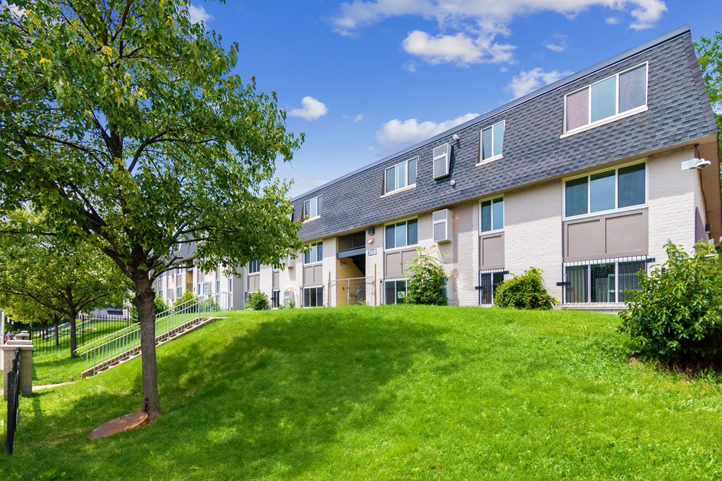 a building with a green lawn and a tree in front of it