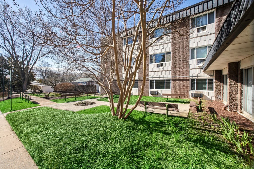a courtyard with benches in front of a building