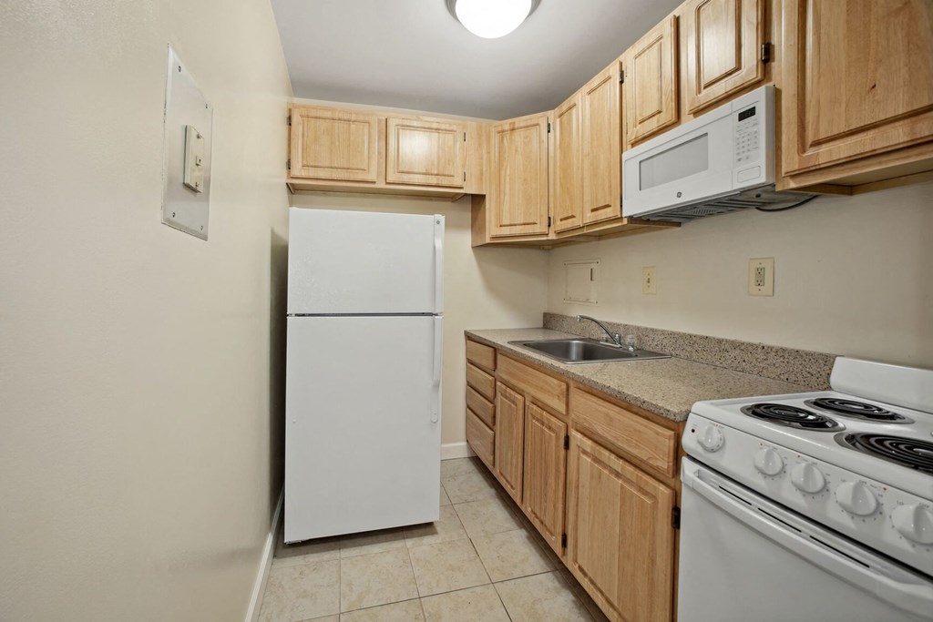 a kitchen with white appliances and wooden cabinets