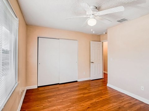 A room with a ceiling fan and a white door.