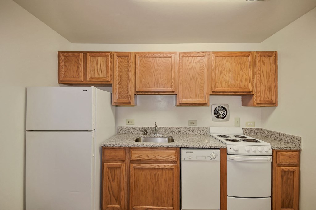 A kitchen with wooden cabinets and white appliances.