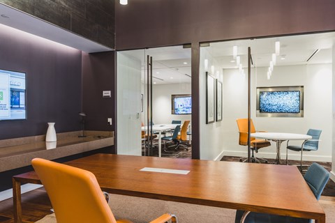 A conference room with a long table and chairs.