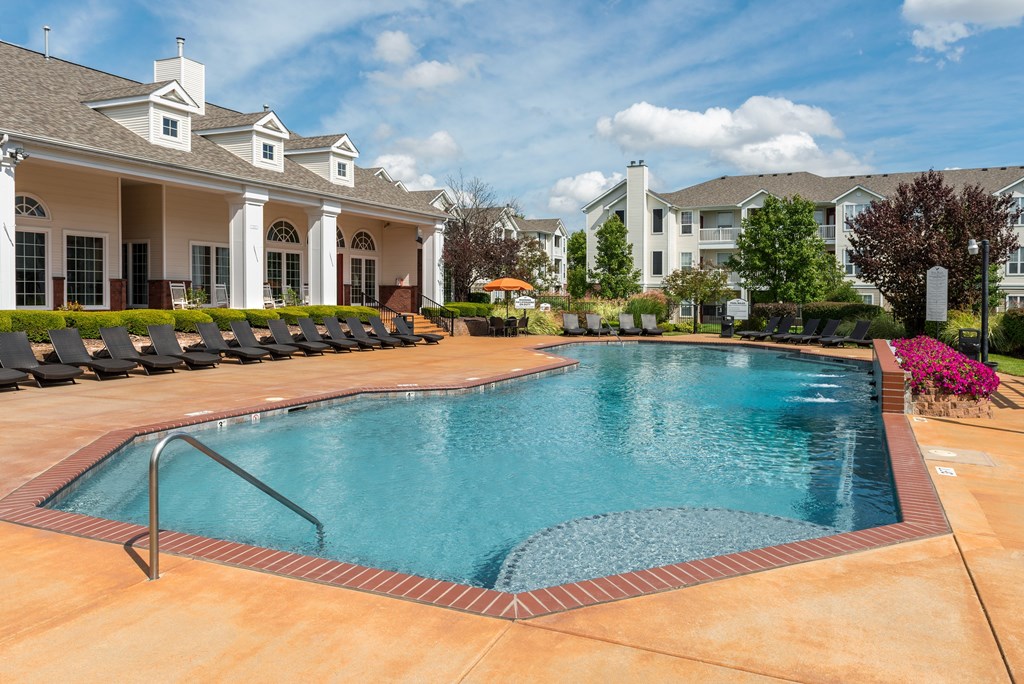 A swimming pool in a residential area with houses in the background.