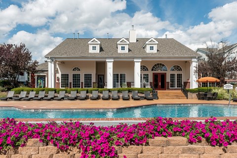 A white house with a pool in front of it.