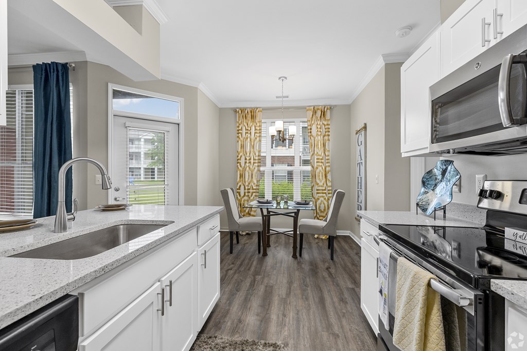 A kitchen with white cabinets and a black stove top oven.