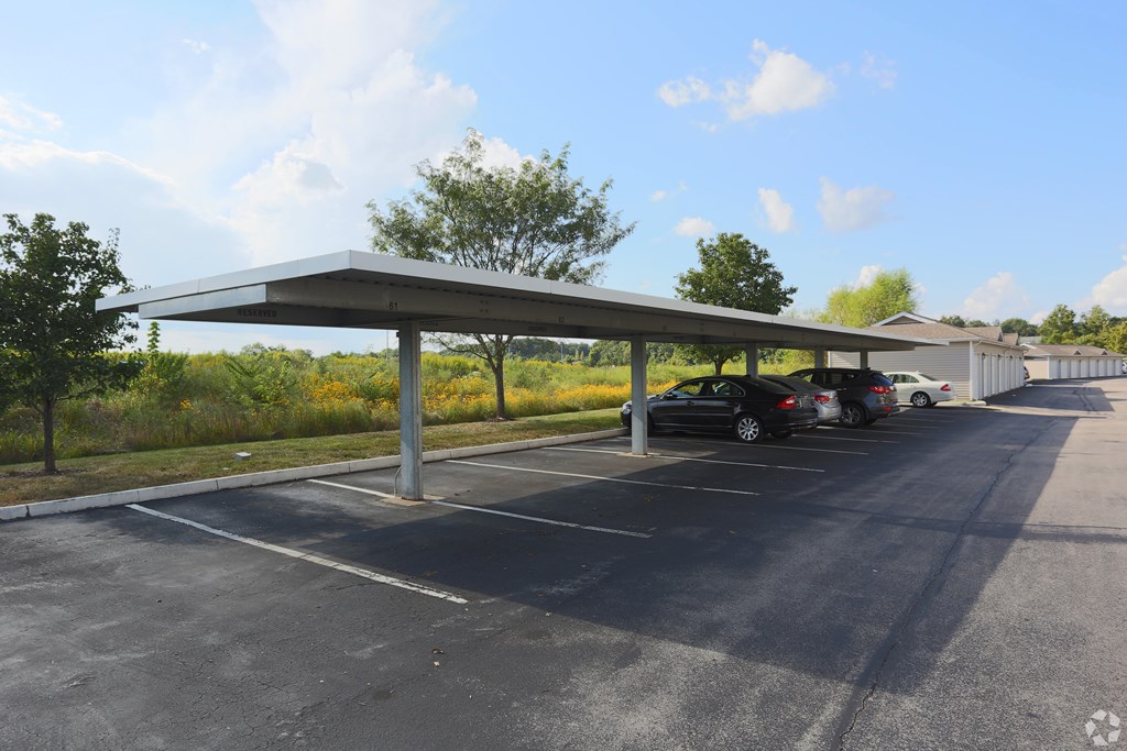 A parking lot with a canopy and cars parked underneath.