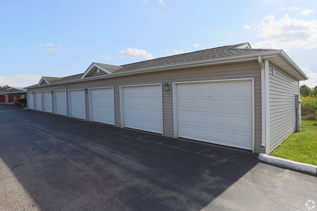 A long garage with two doors is situated on a street.