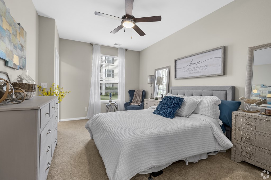 A bedroom with a large bed and a ceiling fan.