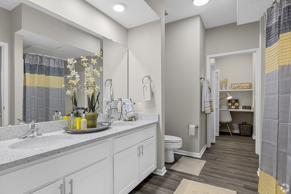 A bathroom with a white vanity and a mirror above it.