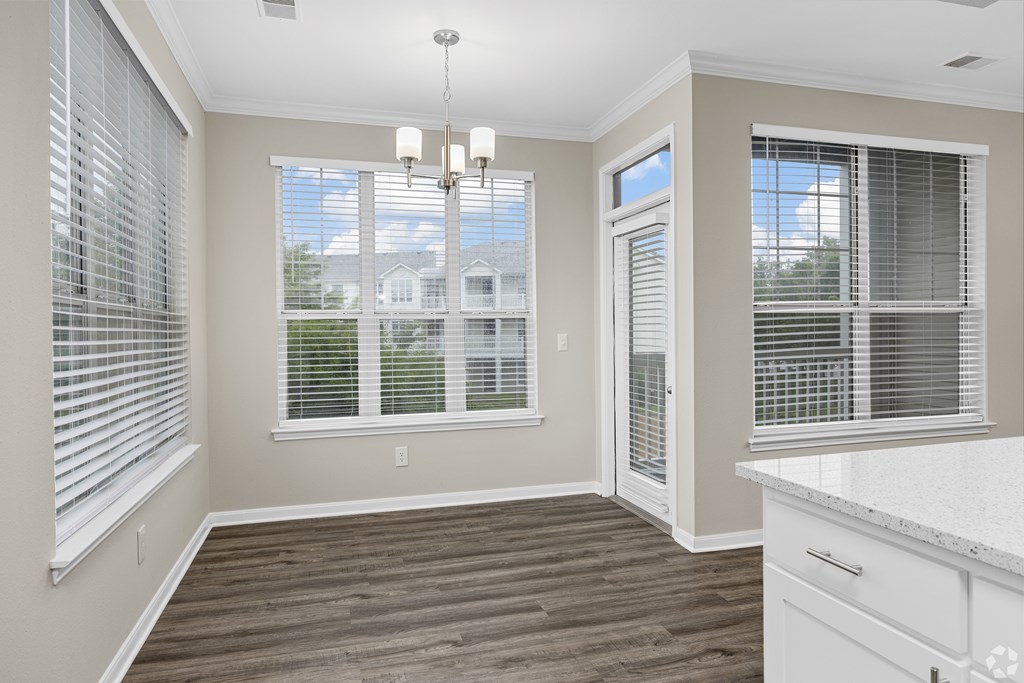 A room with a window and a chandelier.