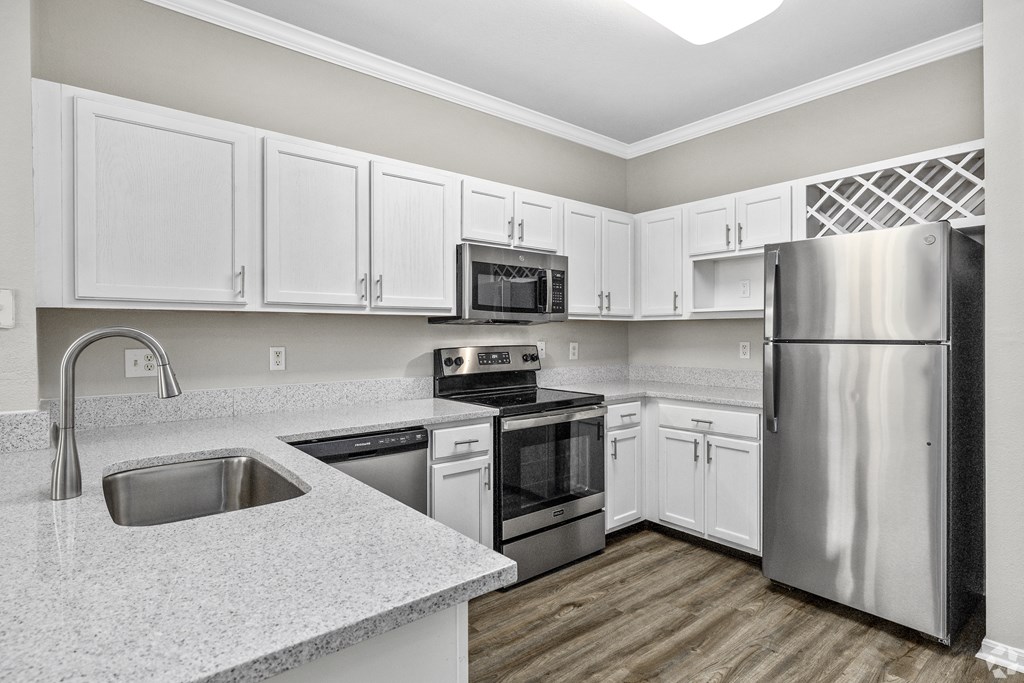 A kitchen with white cabinets and stainless steel appliances.