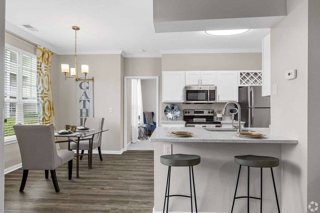 A kitchen with a dining table and chairs.