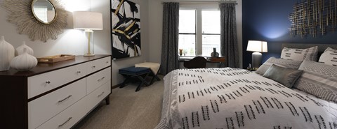 A bedroom with a large bed and a wooden dresser.