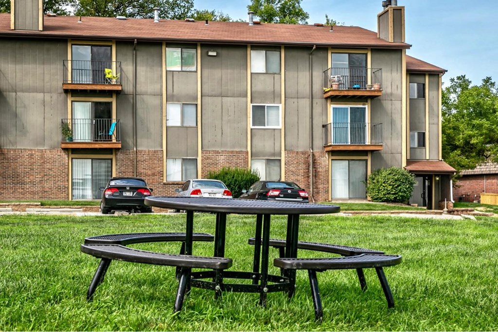 a table and two chairs in front of an apartment building