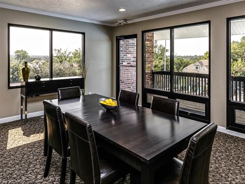 a dining room with a table and chairs and windows