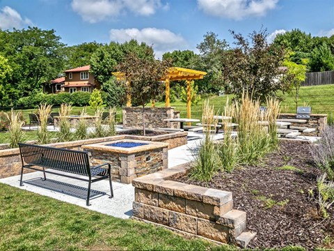 a backyard with benches and a patio with a hot pool