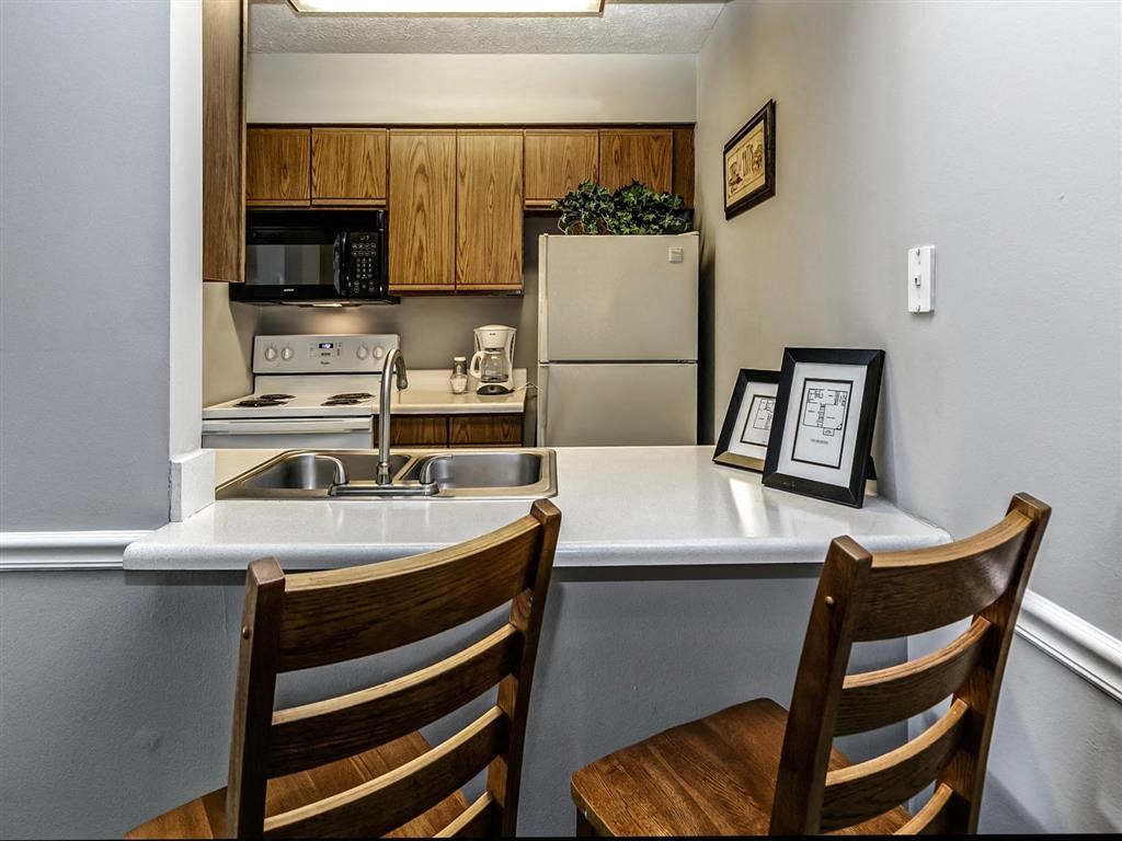 a kitchen with a counter and two chairs