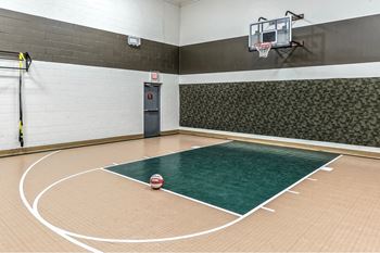 a basketball court in a gym with a basketball hoop and a ball on the floor