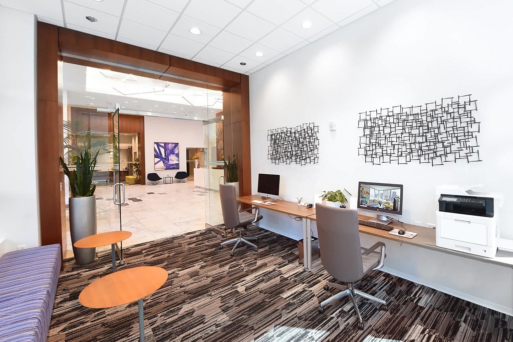 A modern office with a purple sofa and a wooden desk at Two Twelve Clayton Apartments, Clayton 63105