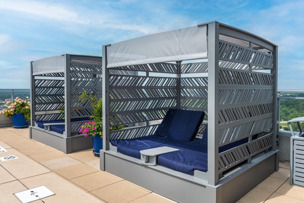 Two beds with blue pillows and grey striped headboards at Two Twelve Clayton Apartments, Clayton, Missouri